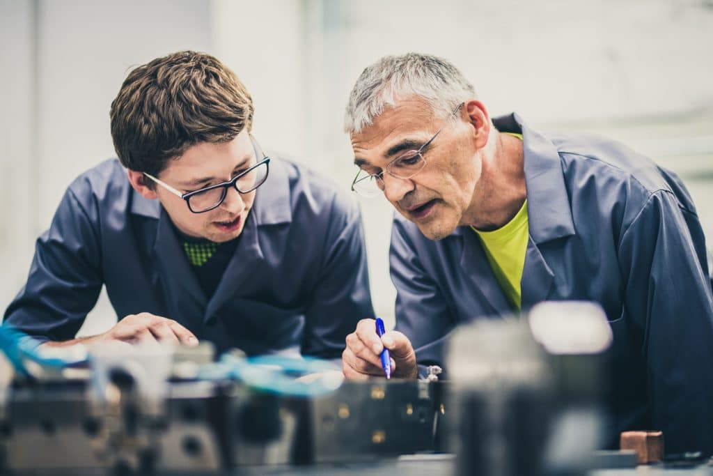 Instructor works one-on-one with student in trade school program shop