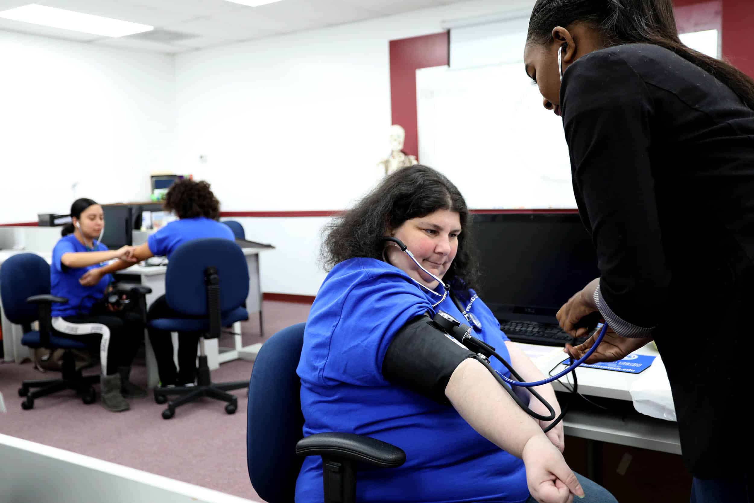 Woman's Heart Rate Being Checked by Medical Assistant Student 