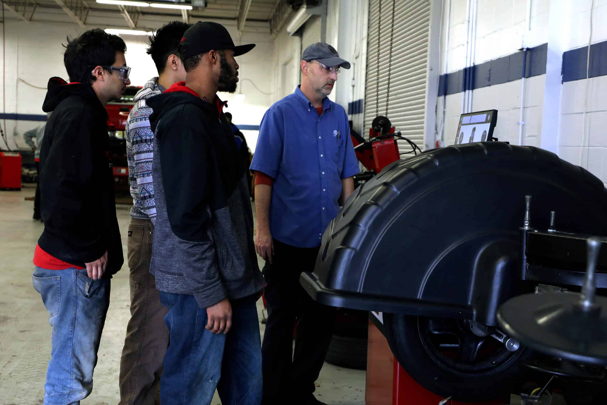 Automotive Instructor Talking to Students About Wheel Well