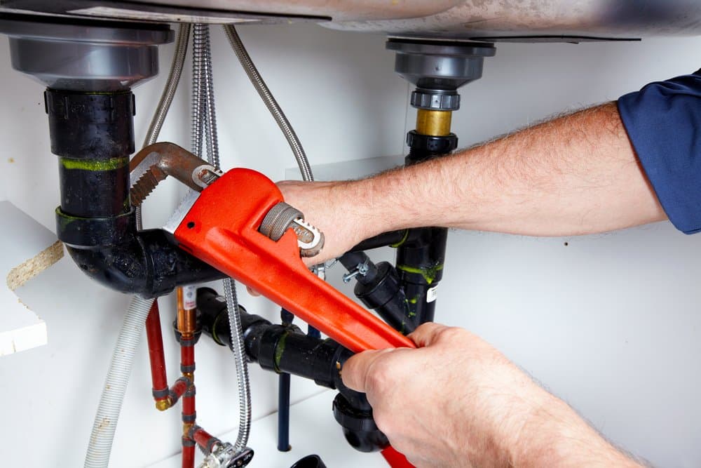 Plumbing Student Using Wrench to Adjust Sink
