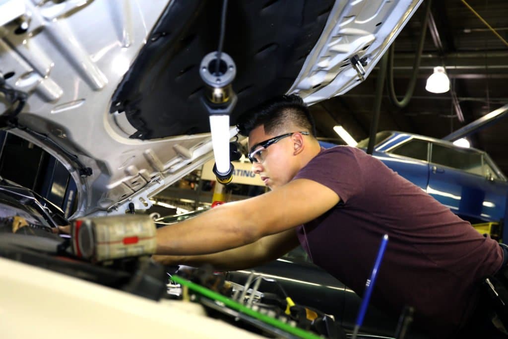 Auto mechanic student working on car