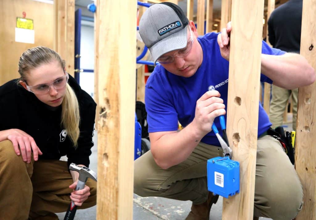 Electrician student working electrical wire box