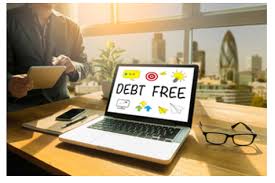 Student in classroom stands near open laptop with message “debt free” showing on screen
