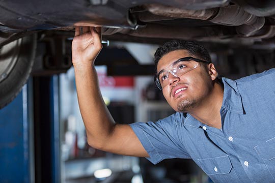 Auto Tech Working On Vehicle