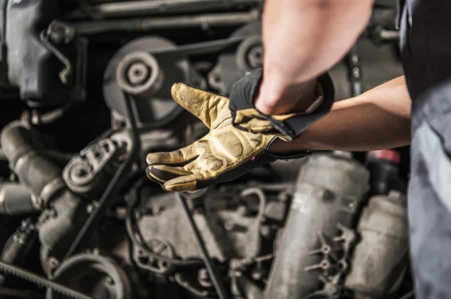 Technician working on diesel truck engine pulling on gloves