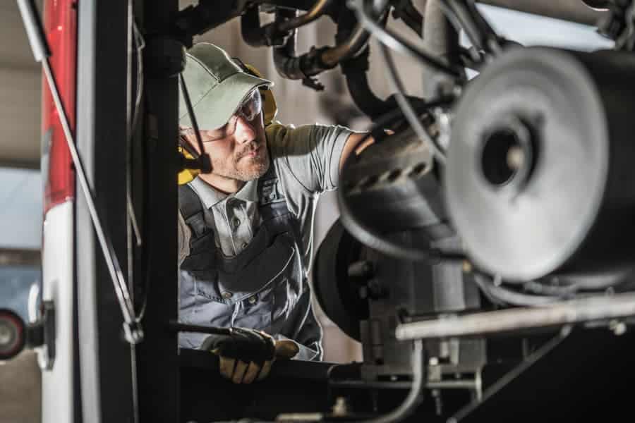 A diesel mechanic inspects a vehicle