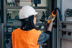 A service technician tests voltage with a digital multimeter