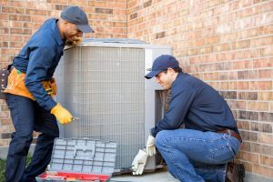 Team of technicians installing an HVAC unit