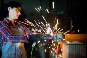 Person welding while wearing safety glasses and gloves