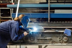 Welder working in a factory wearing protective safety gear