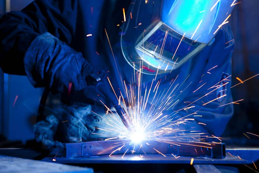 Student welding steel in classroom