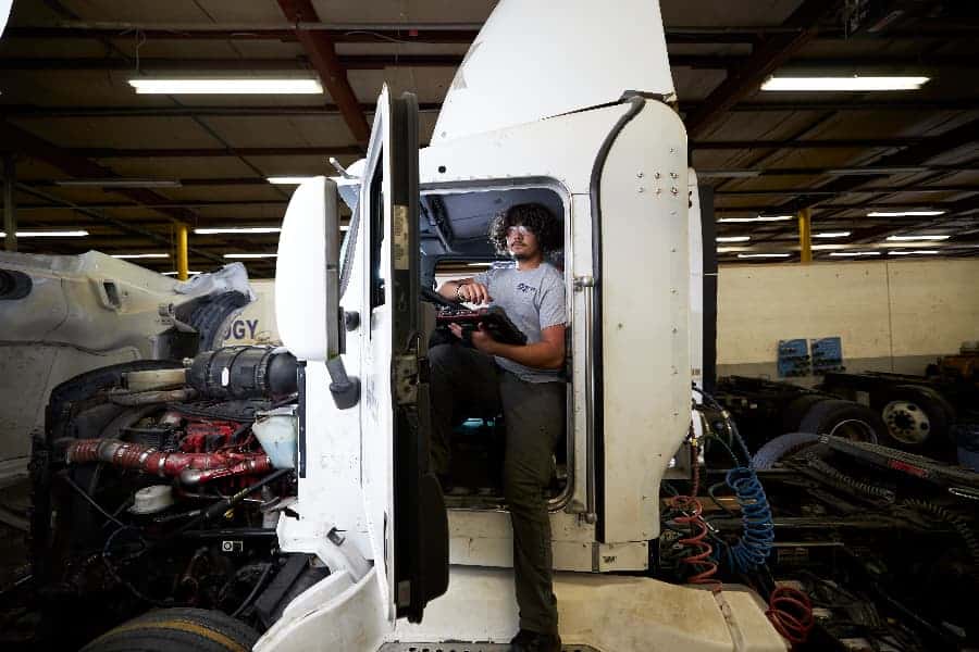 Diesel Truck Instructor and Student Working Under Hood