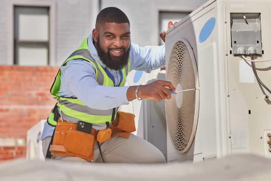 Smiling HVAC technician completing AC repair