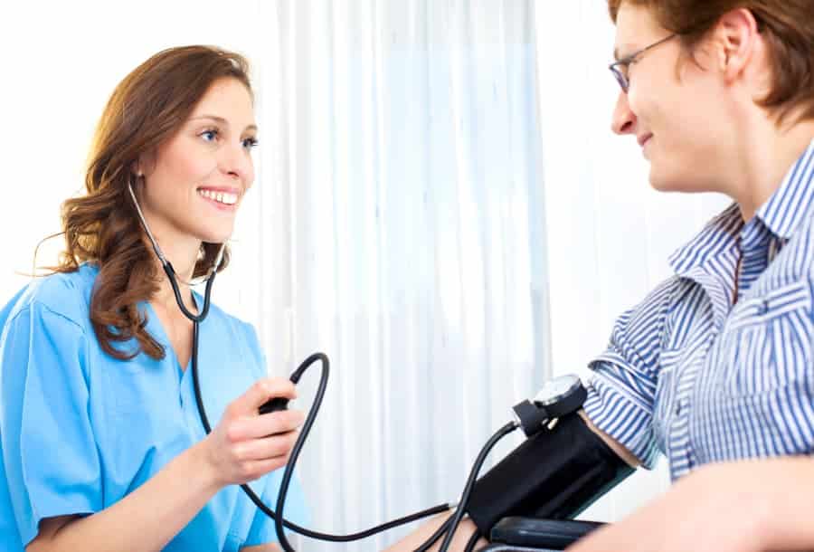 Medical assistant taking blood pressure
